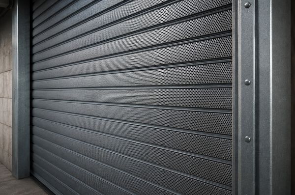 Persiana metálica de seguridad microperforada con guías laterales reforzadas